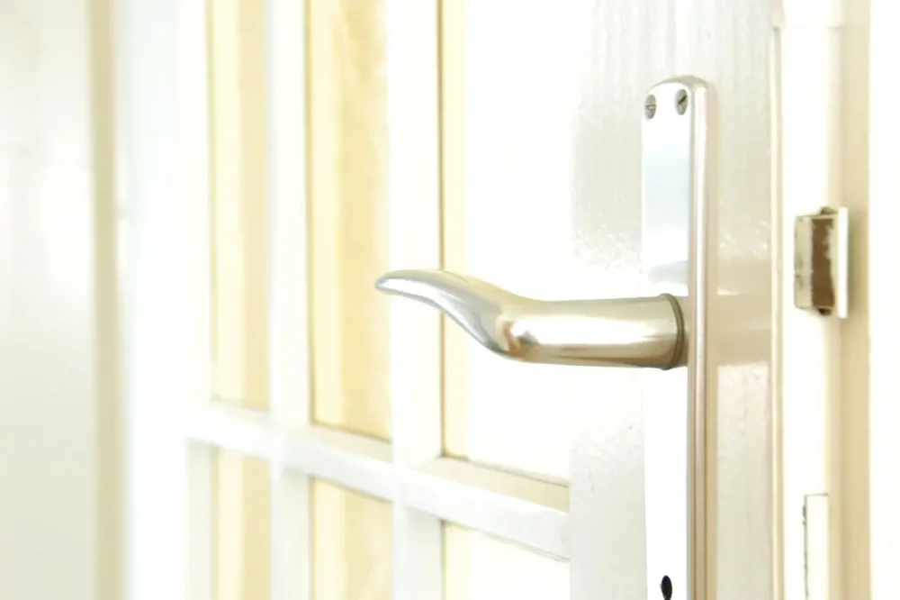 White entrance door with a lever handle and locking plate – locksmith Birmingham city centre advice on communal and flat entrance doors from Locksmith Birmingham